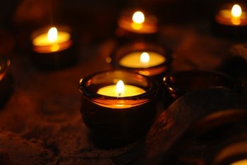Ökumenische Exerzitien im Alltag und ökumenischer Gesprächskreis In einem dunklen Raum verbreiten brennende Teelichte Wärme und Licht